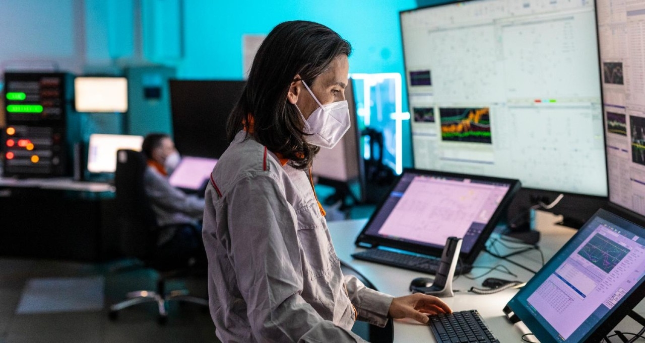 Trabajadora de la refinería vigilando la actividad en unas pantallas