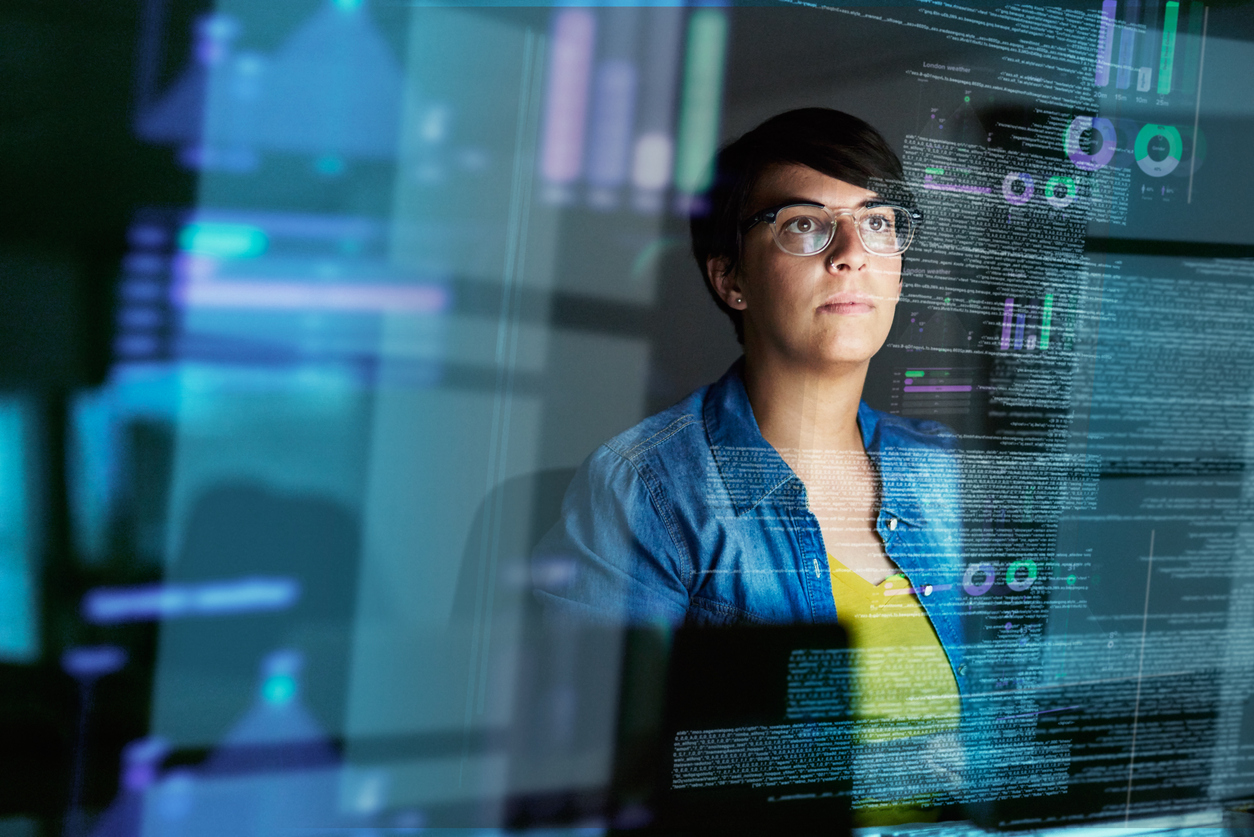 A woman typing at a computer where you can see the data