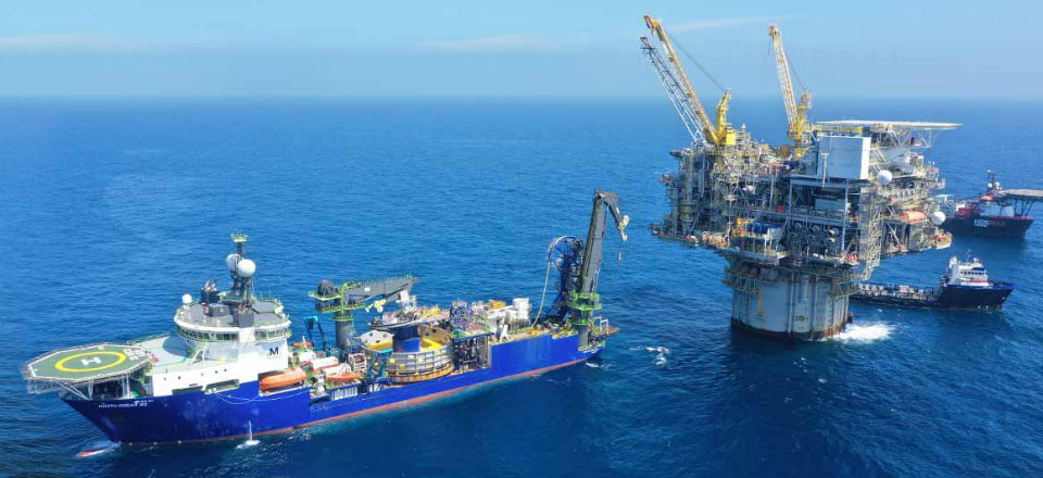 Aerial view of a ship and a platform at sea. 