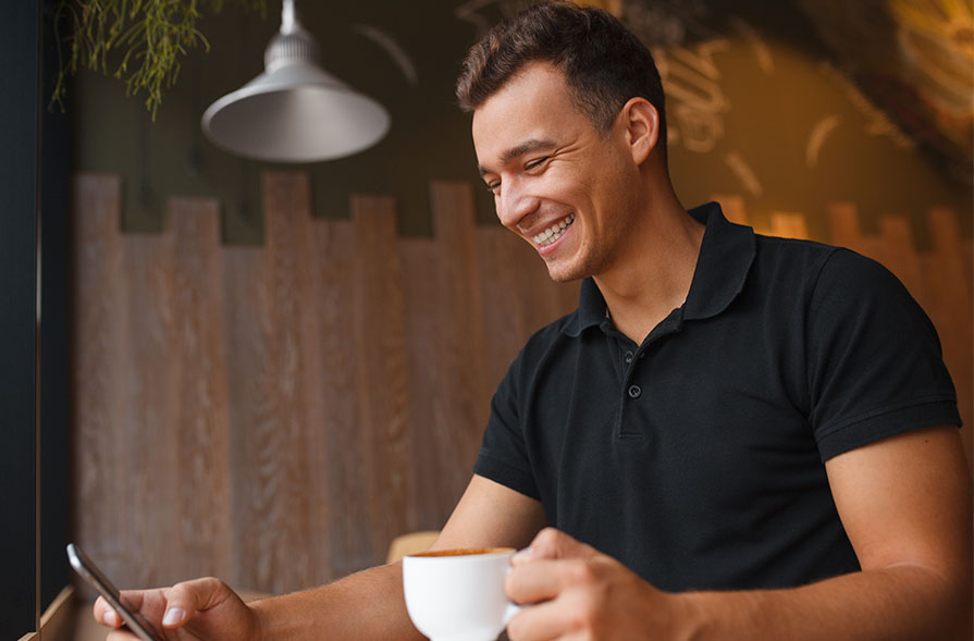 Un hombre con una taza de café y un móvil