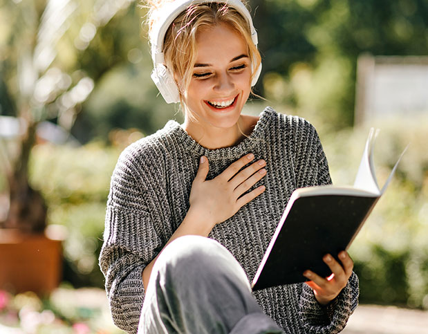 Una mujer con cascos y un libro en la mano