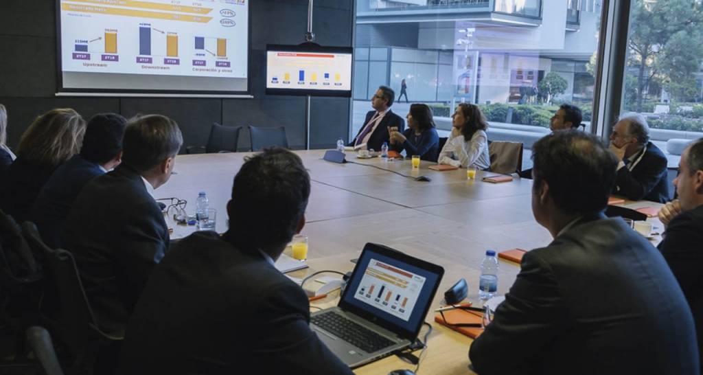 Group of people in a conference room looking at a projection of graphs