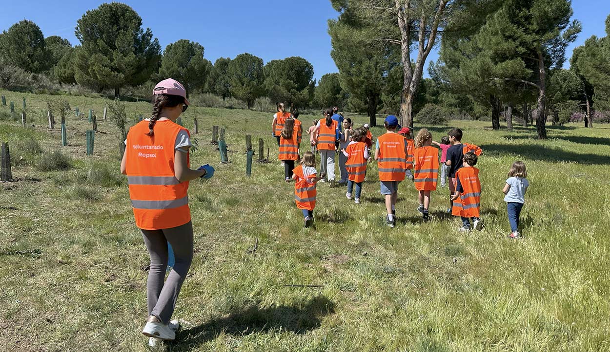 personas con chalecos de voluntariado repsol en el campo