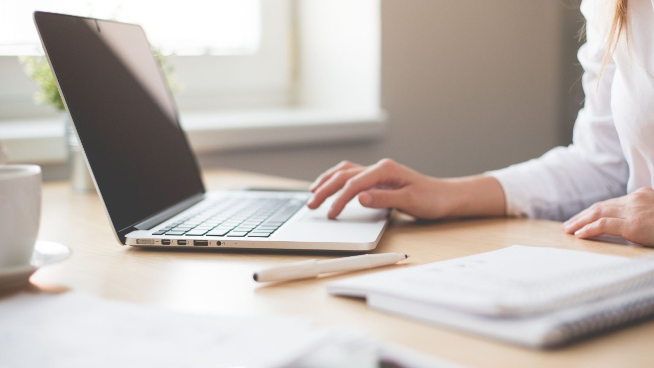A person with a laptop on a desk