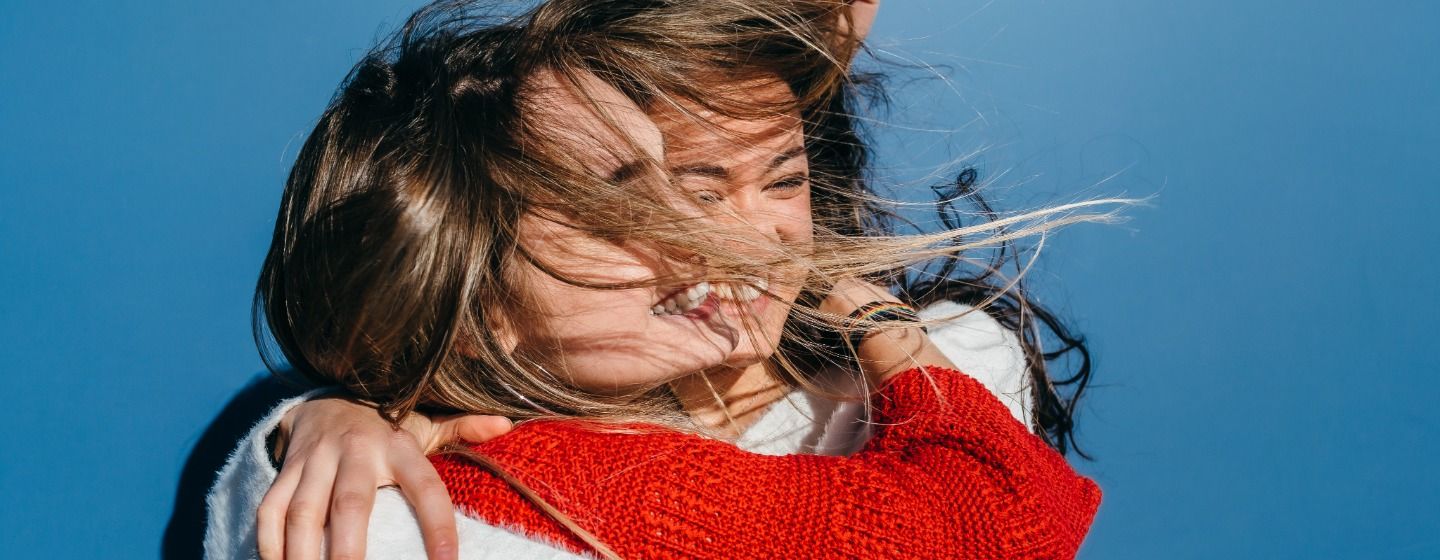 Two smiling girls hugging each other