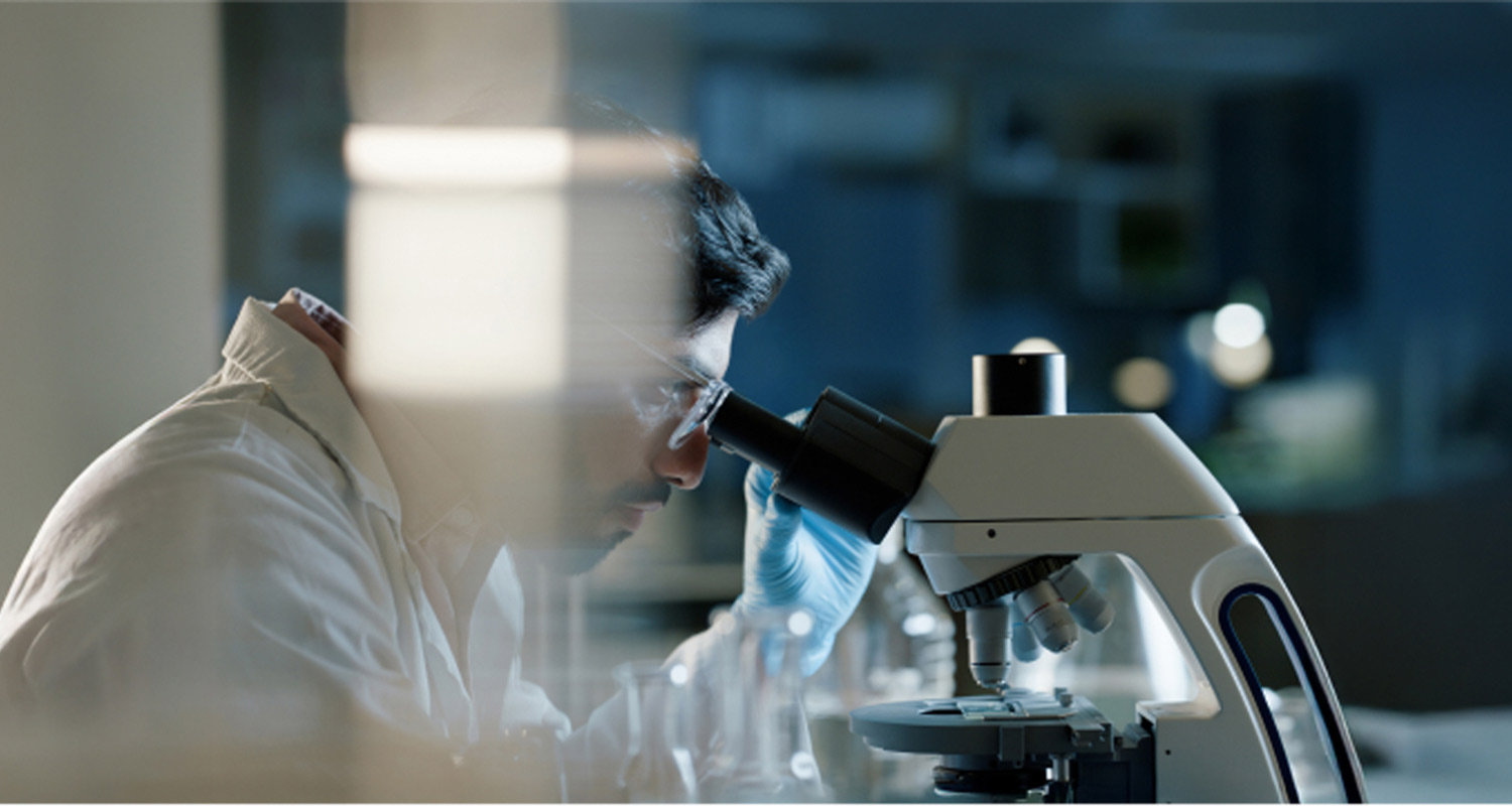Científico mirando tras microscopio
