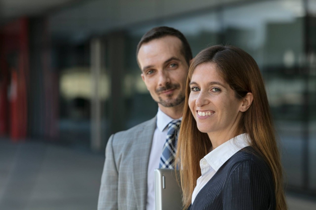 Dos empleados posan sonrientes