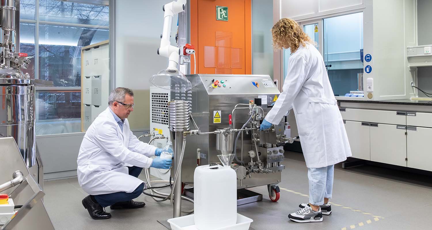 Researchers working with a homogenizer