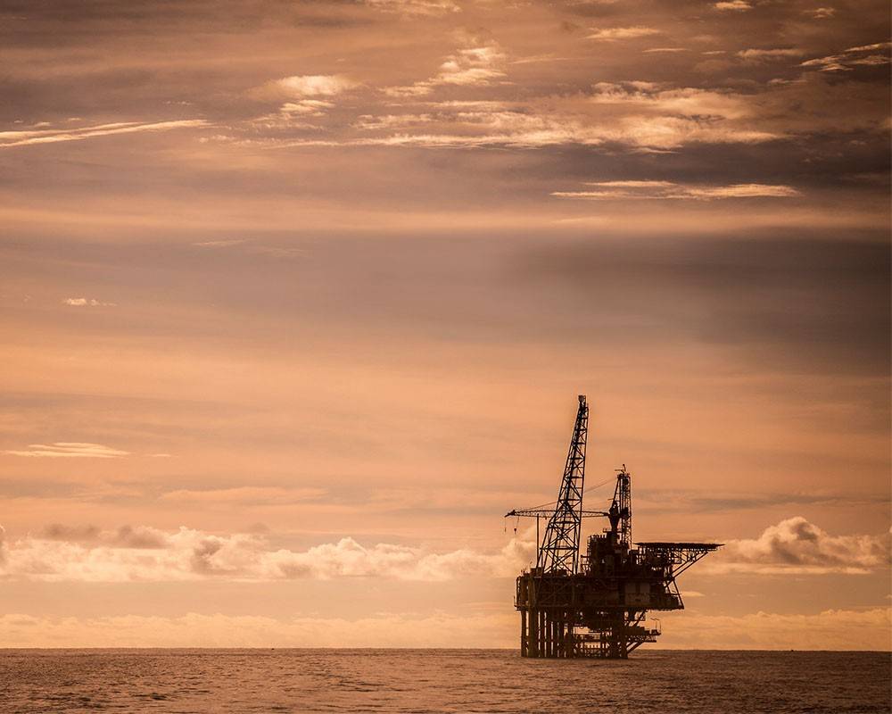 View of an offshore oil rig at sunset.