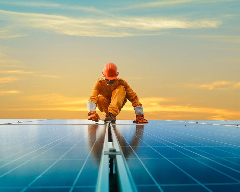 Un trabajador encima de un panel de placas solares
