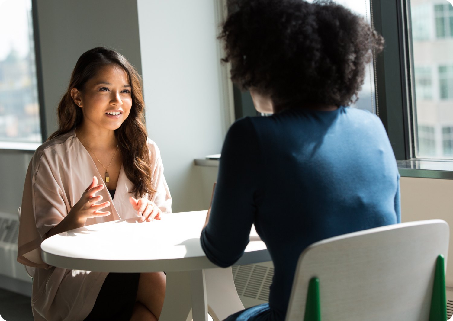 Dos mujeres conversando frente a frente en una mesa