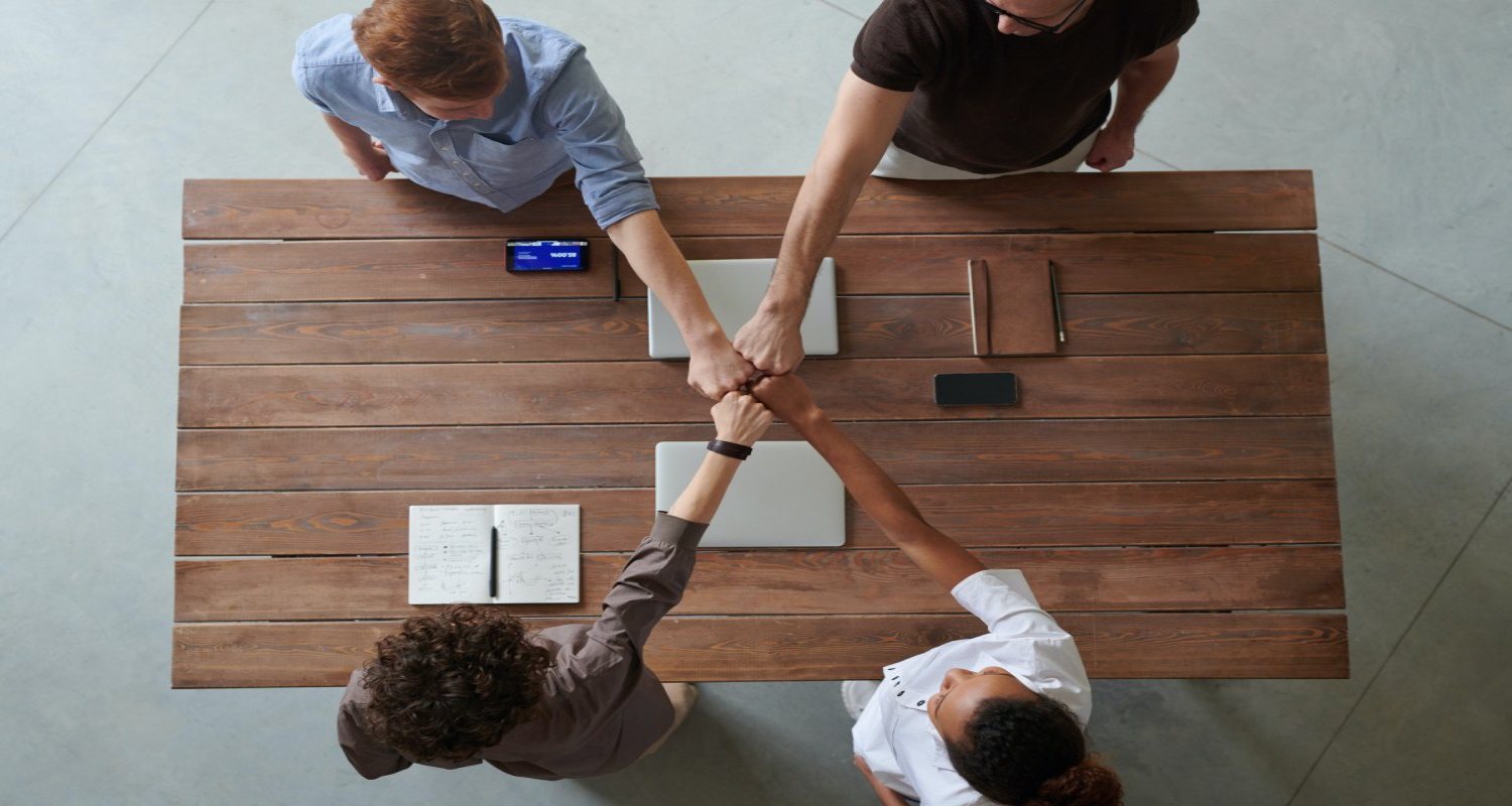 Personas dándose la mano encima de una mesa