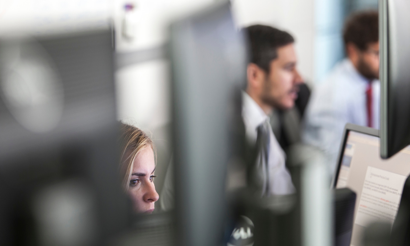 Dos personas trabajando frente ordenadores en una oficina 