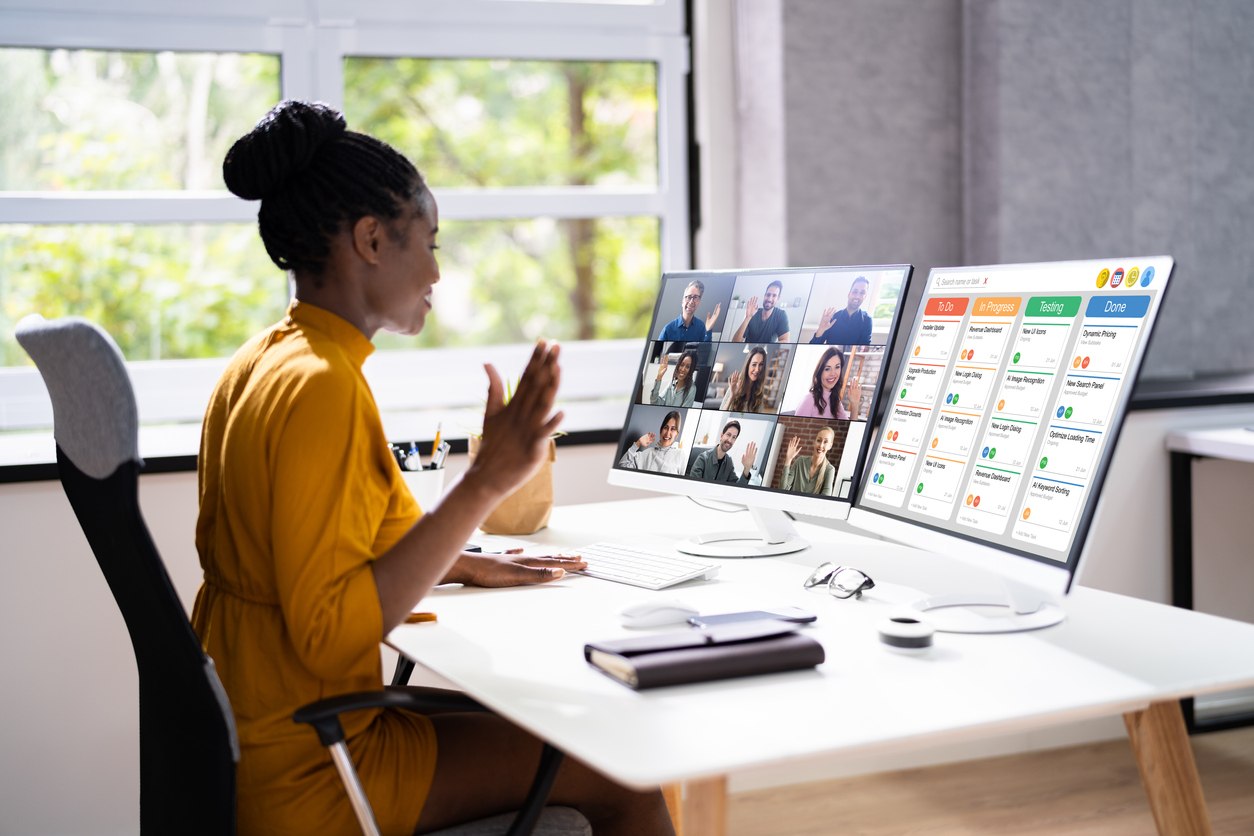 A woman in front of two screens with Kanban