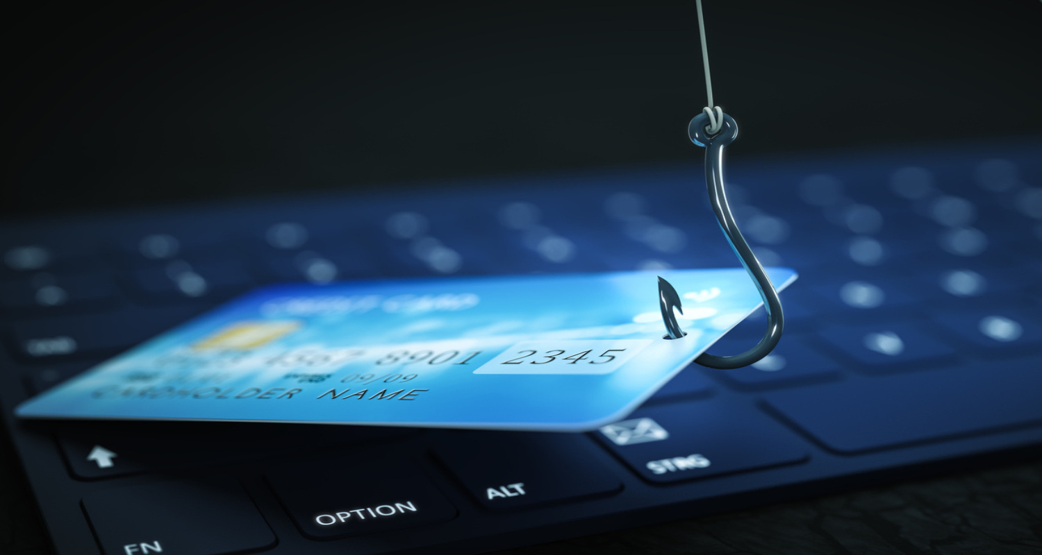 A credit card with a hook on top of a keyboard