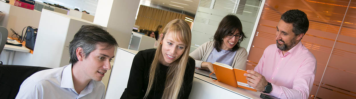 Relaciones entre empleados y empresa. Dos mujeres hablando en el interior de una oficina 