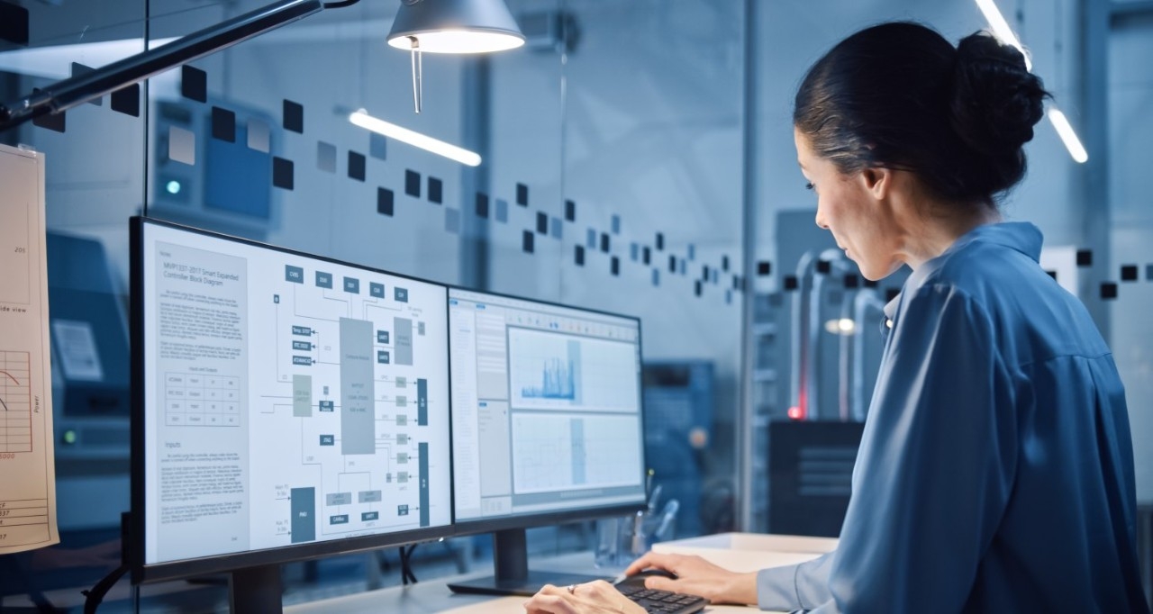Una mujer trabajando con dos pantallas