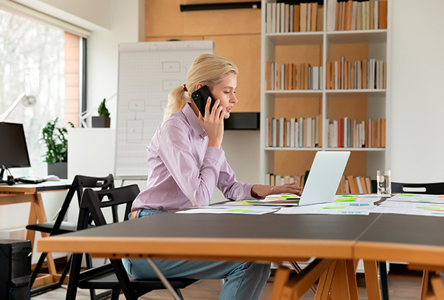 Mujer trabajando y hablando por telefono