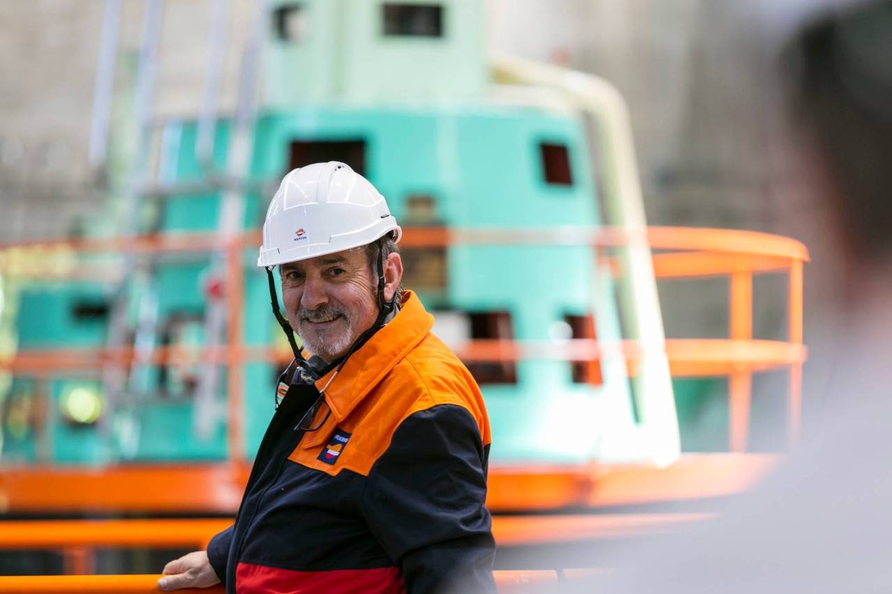 An operator smiling in front of Repsol facilities