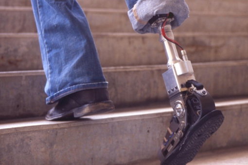 Capacidades diferentes. Vista en primer plano de una persona subiendo unas escaleras con una pierna ortopédica 