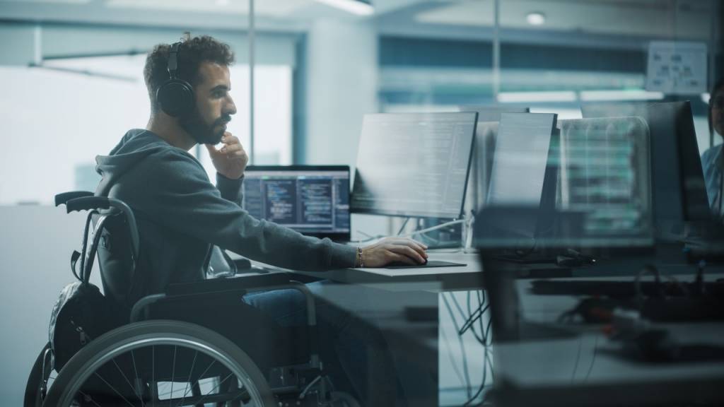 hombre en silla de ruedas trabajando con un ordenador