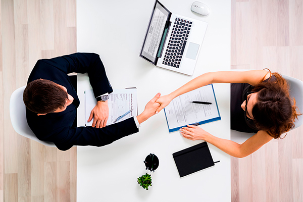 Two people shaking hands after an interview