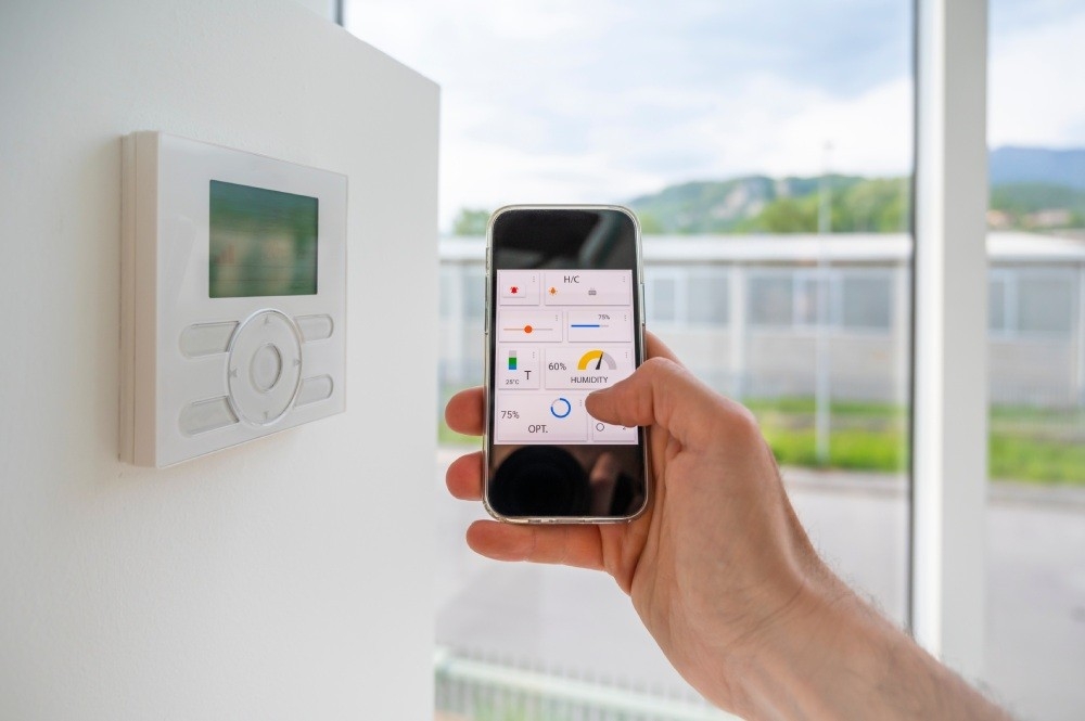 A person managing their home from their cell phone