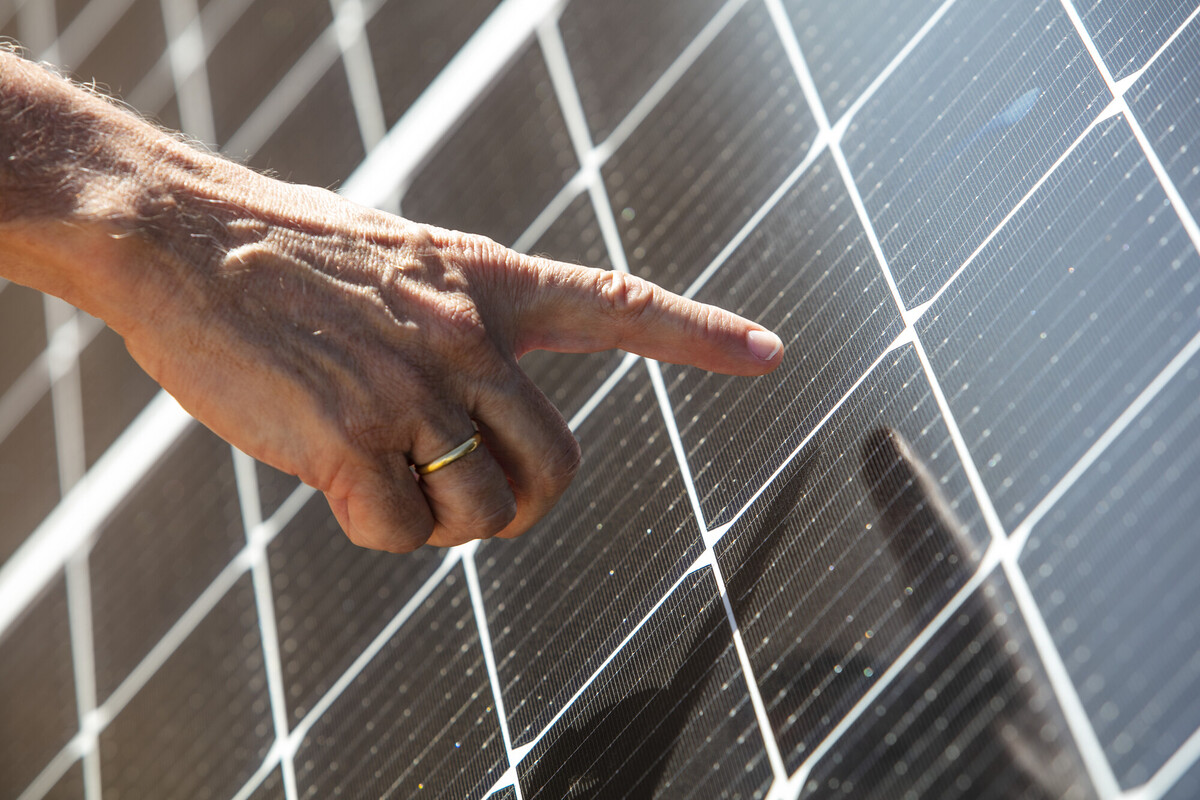 A hand pointing at a solar panel