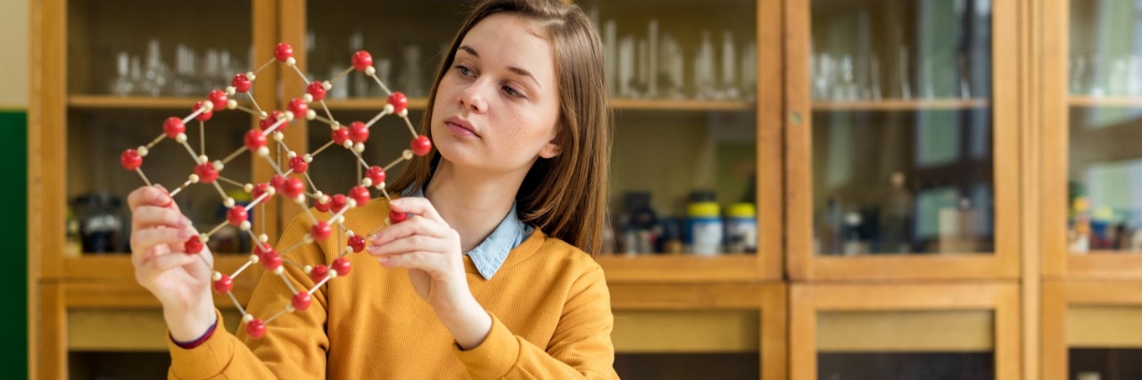 A girl holding a chain of atoms