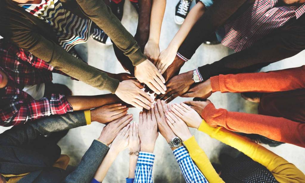 Group of people joining hands as a sign of teamwork