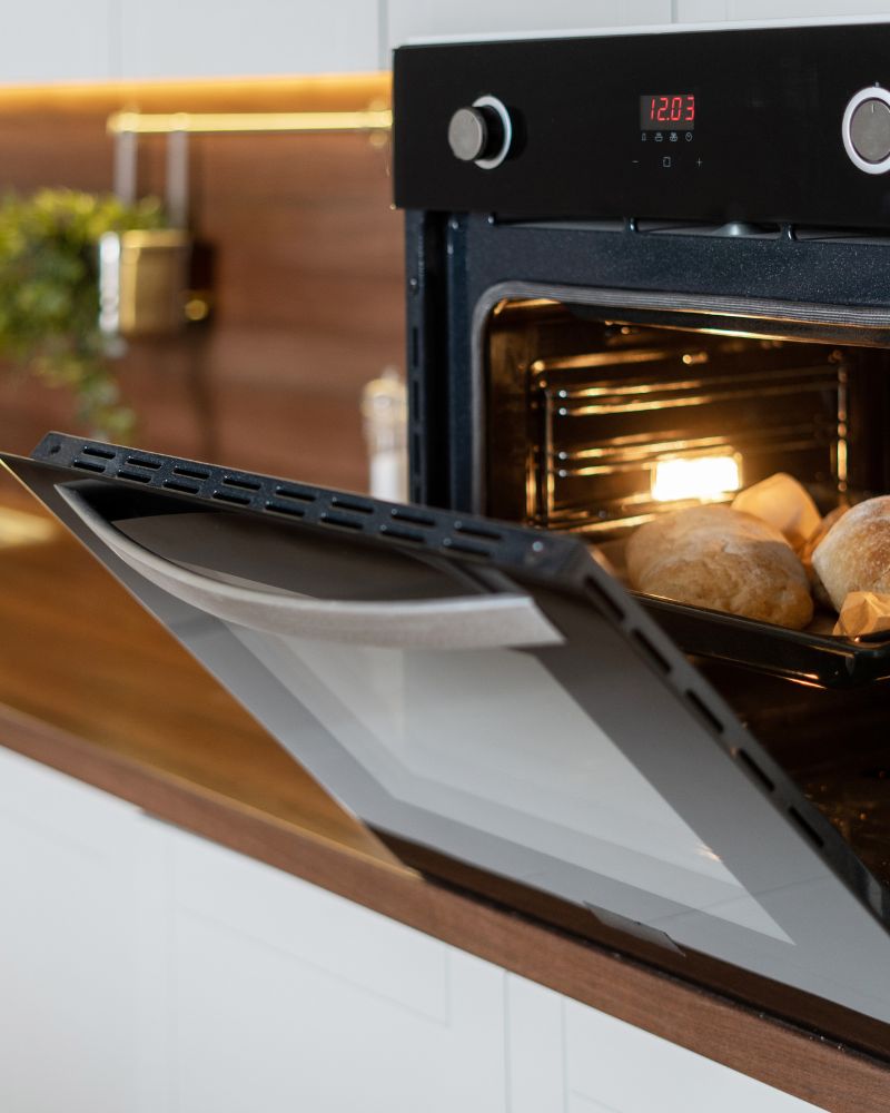 oven door open with potatoes cooking inside