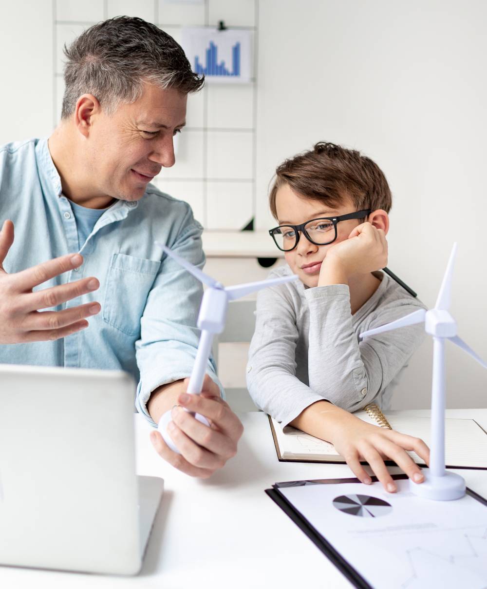 man showing a child what a wind farm looks like