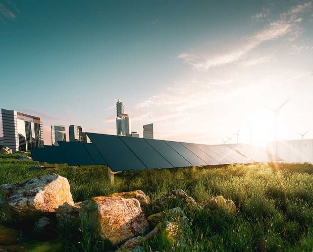 paneles solares en el campo con una ciudad al fondo