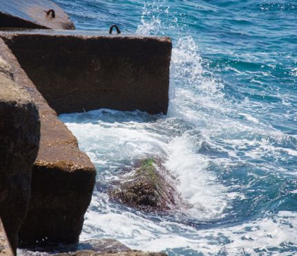 Una imagen de olas rompiendo contra las rocas