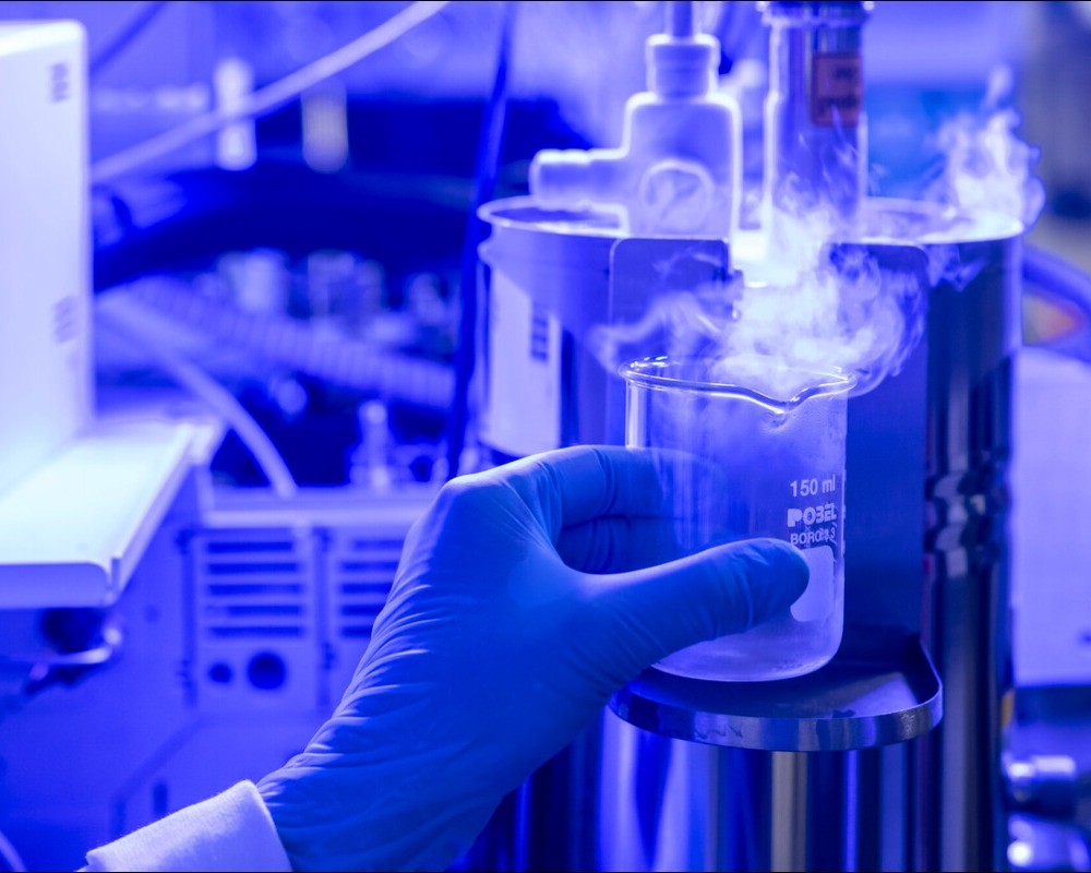 Mano con guante sujetando una muestra en el laboratorio de cromatografía