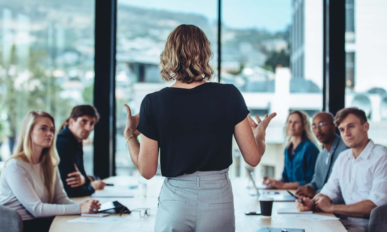 Una mujer liderando una mesa de trabajo 