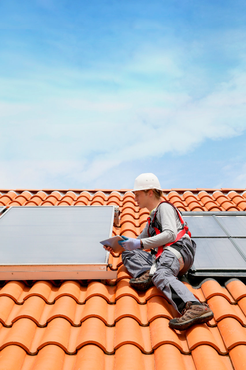 Solar panel maintenance technician on a roof