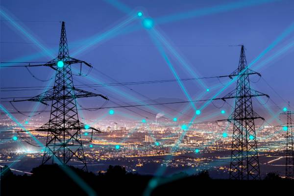 A city lit up at night showing virtual connections between buildings and transmission towers