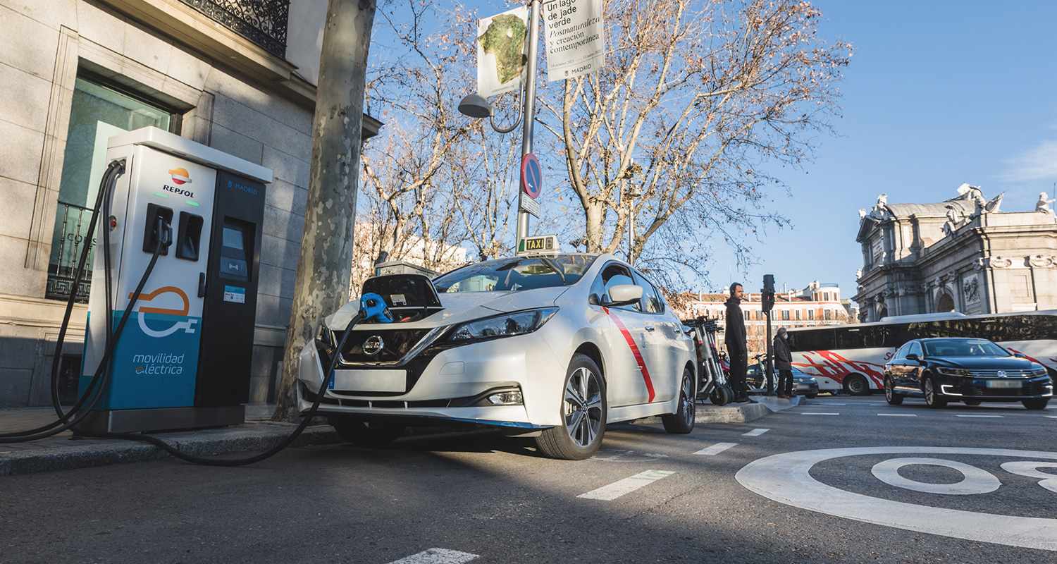 Taxi eléctrico recargando su batería en la calle