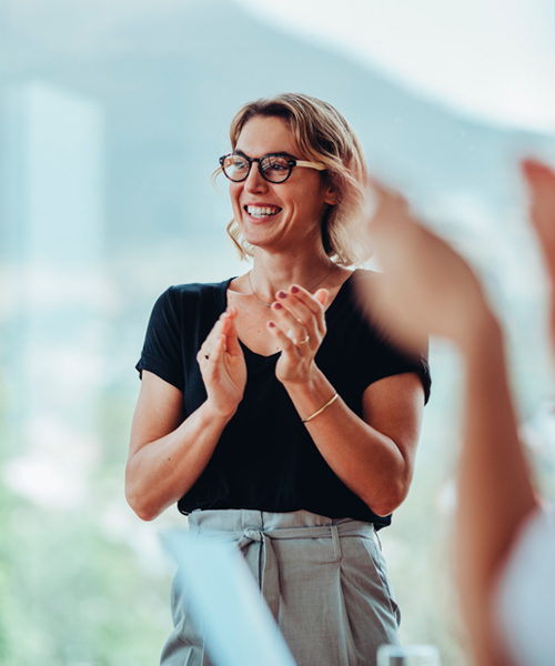 Una sonriente mujer trabajadora que junta las manos