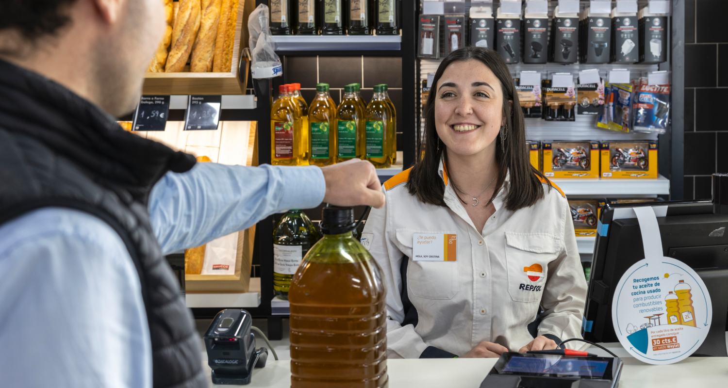 Marc Marquez deposita una botella de aceite de cocina usado en un contenedor de Repsol