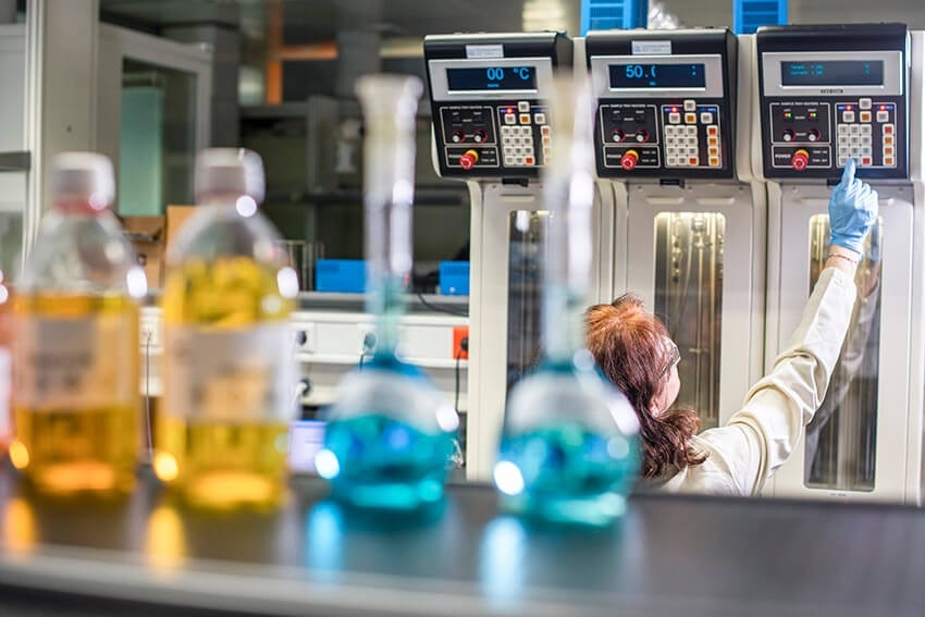 Researcher in lab with flasks