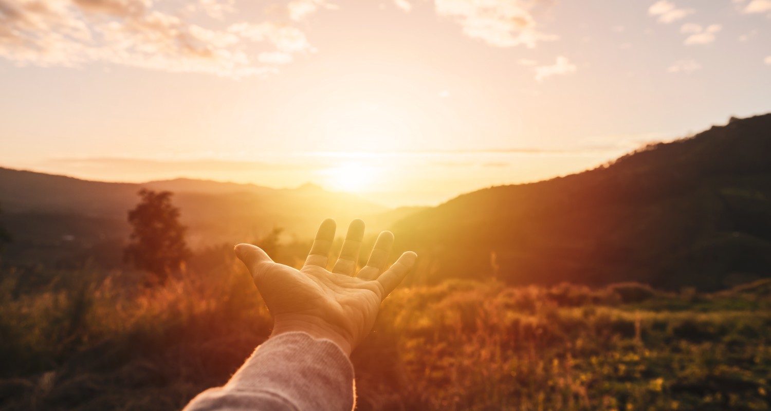 A hand outstretched in a sunset