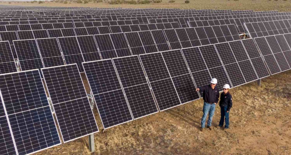 Two operators next to solar panels
