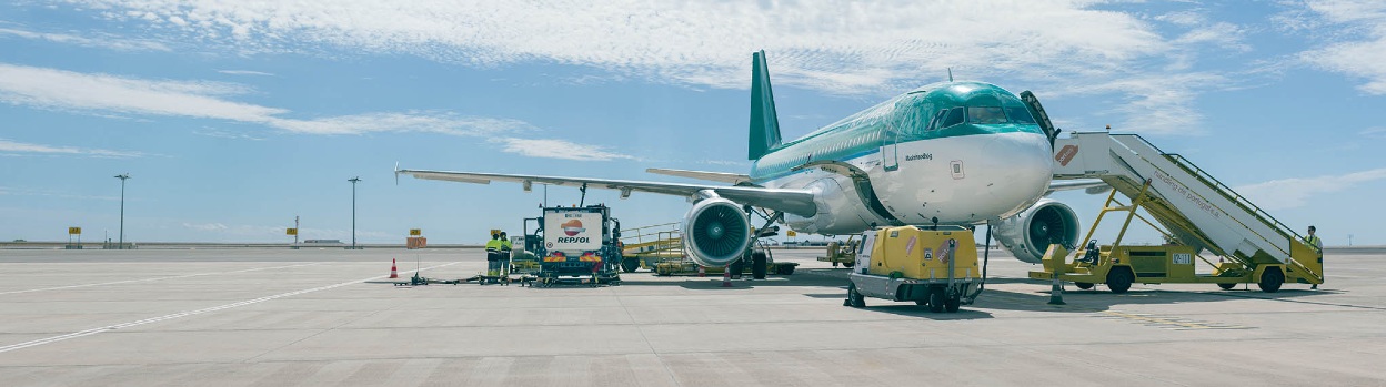 Fueling an aircraft at the airport from a Repsol-branded refueling truck.