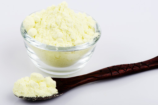 A container and a wooden spoon with sulfur