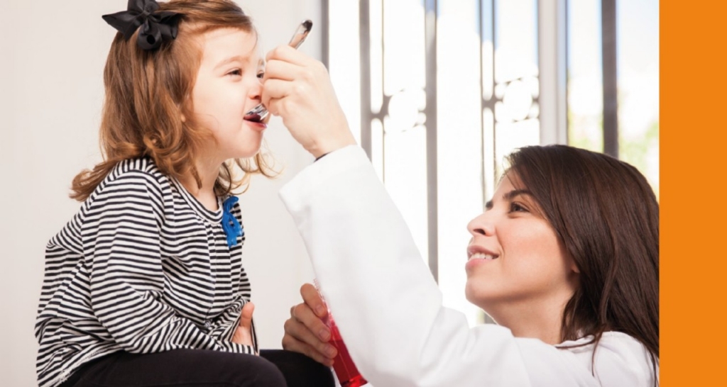 Woman giving medicine to a girl