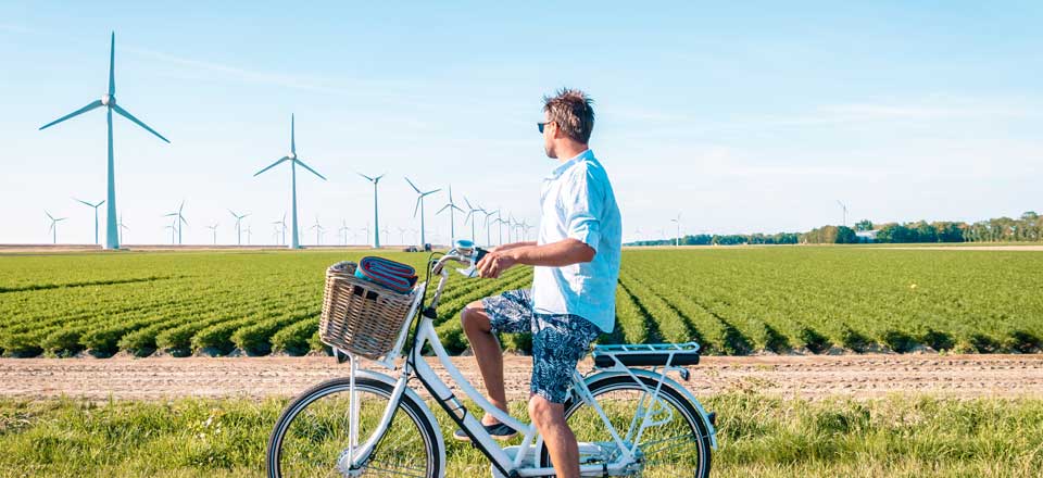 a man on a bicycle looking at a windfarm