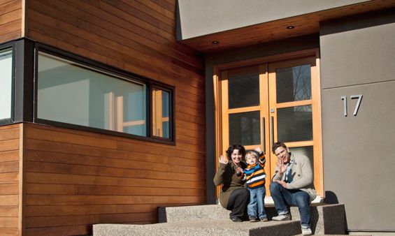 Family waving at entrance to their house