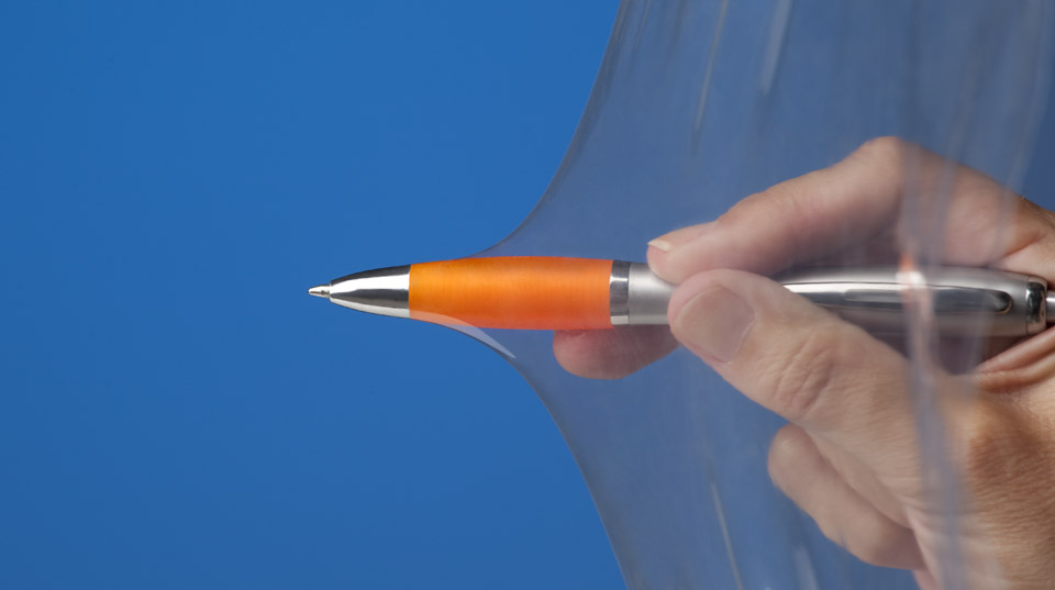 Intentando atravesar un plástico Resistex con un bolígrafo naranja